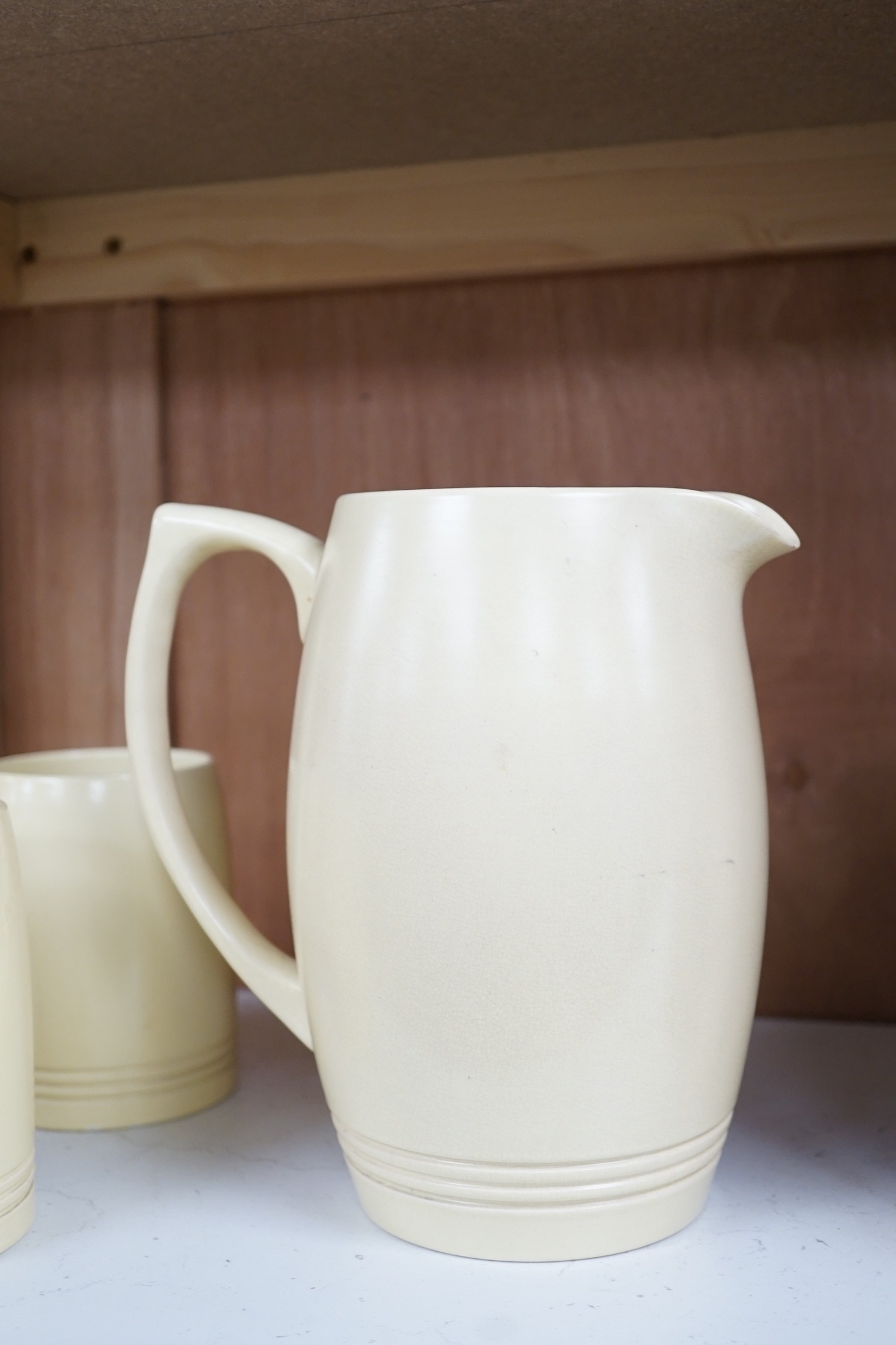 Keith Murray for Wedgwood- a cream-glazed jug and six similar mugs, jug 20.5cms high